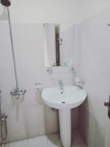 a white bathroom with a sink and a shower at HS Global Apartments in Rawalpindi