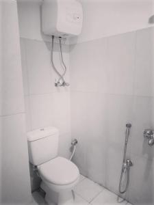 a white bathroom with a toilet and a shower at HS Global Apartments in Rawalpindi