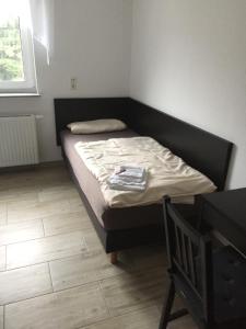 a small bed in a room with a wooden floor at Hotel Engel in Waldbronn