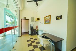 einen Flur mit einem Schreibtisch und Stühlen in einem Zimmer in der Unterkunft CMN Hotel & Homestay in Sungai Petani