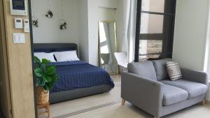 a bedroom with a bed and a couch and a mirror at The Mark Sokcho Residence #16 Level in Sokcho