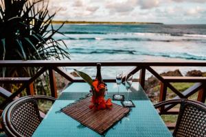 einen Tisch mit einer Flasche Wein und zwei Gläsern in der Unterkunft Nasama Resort in Port Vila