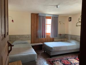 um quarto com 2 camas e uma janela em Hotel Lyshaus em Gressoney-Saint-Jean