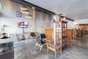 Cette chambre dispose de chaises, d'une table et d'une télévision. dans l'établissement Intown Residence, à Bangkok