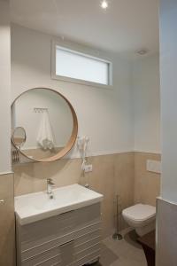 uma casa de banho com um lavatório, um espelho e um WC. em LO SGUARDO em Sulzano