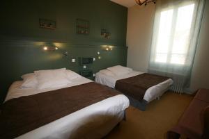 2 camas en una habitación con paredes verdes en Hôtel Le Picardy, en Saint-Dizier