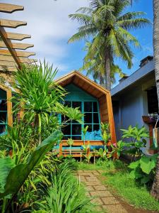 a house with a palm tree in front of it at Absolute Villa in Gili Trawangan