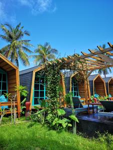 a house with a pergola in the yard at Absolute Villa in Gili Trawangan