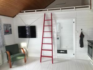 a red ladder in a room with a tv and a chair at Ludvigbua in Stamsund