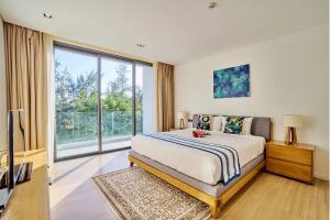 a bedroom with a bed and a large window at Clean & Quiet Villa - The Point Resort in Da Nang
