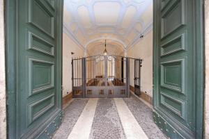 an entrance to a building with green doors at La Maisonnette Tritone Trevi Apartment Rome in Rome