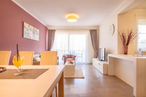 a kitchen and living room with yellow chairs and a counter at Luxury Apartments Villa Mande in Malinska +88 photos