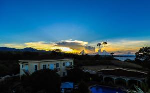 a view of a house with the sunset in the background at Star View Boutique Resort in Dumaguete