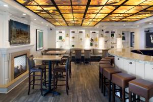 a restaurant with a bar and stools at Holiday Inn - Bloomington W MSP Airport Area, an IHG Hotel in Bloomington