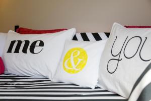 a group of pillows on a bed with the words me and row at Studio Cottage - Walk to the Lake & Town in Taupo