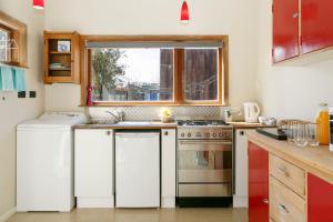 a kitchen with a sink and a stove and a window at Studio Cottage - Walk to the Lake & Town in Taupo