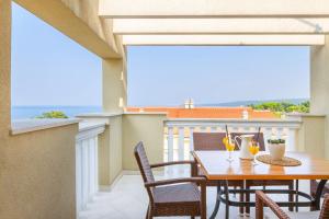 a patio with a table and chairs on a balcony at Luxury Apartments Villa Mande in Malinska