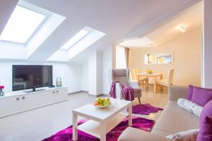 uma sala de estar com um sofá, uma televisão e uma mesa em Luxury Apartments Villa Mande em Malinska