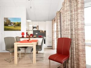 une cuisine et une salle à manger avec une table et des chaises dans l'établissement Dänische Ferienhäuser am Salzhaff Haus Vogelparadies, à Poel 18 autres photos