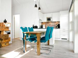 een keuken met een houten tafel en blauwe stoelen bij Dänische Ferienhäuser am Salzhaff Haus am Salzhaff in Insel Poel