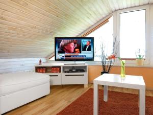 a living room with a tv and a white couch at Hus in de Sünn in Insel Poel