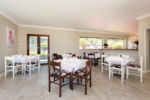 a dining room with white tables and chairs at The Gregory in Pinetown