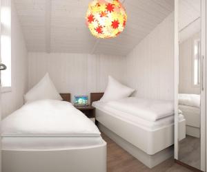 sypialnia z 2 łóżkami i lampką w obiekcie Dänische Ferienhäuser am Salzhaff Haus Vogelparadies w mieście Wyspa Poel
