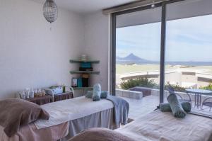 a room with two beds with a view of the ocean at Dolphin Beach Hotel Self Catering Apartments in Bloubergstrand
