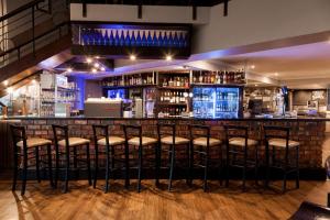 a bar at a restaurant with stools at Dolphin Beach Hotel Self Catering Apartments in Bloubergstrand +17 photos