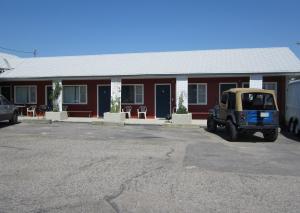 バッファローにあるBig Horn Motelの赤い建物の前に停車した小型車