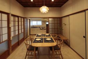 comedor con mesa de madera y sillas en 照宿 Terasu yado, en Aira