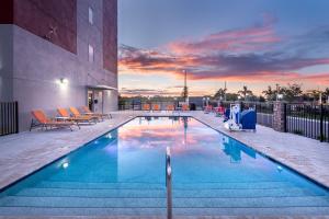 a swimming pool with a sunset in the background at Holiday Inn Express & Suites - Punta Gorda, an IHG Hotel in Punta Gorda
