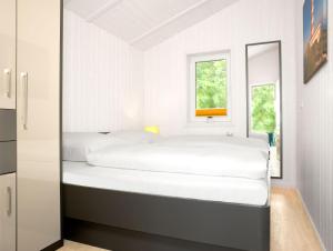 - une chambre blanche avec 2 lits et une fenêtre dans l'établissement Dänische Ferienhäuser am Salzhaff Haus Im Wiesengrund, à Poel