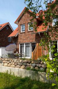 a brick house with a stone wall in front of it at Haus Seeschwalbe in Timmendorf