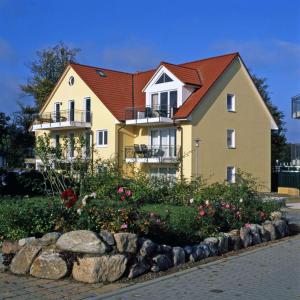 ein großes gelbes Haus mit rotem Dach in der Unterkunft Landhaus Residenz Ostsee Meeresbrise in Insel Poel