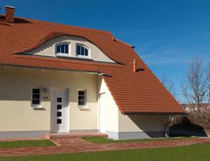 a white house with an orange roof at Bernsteinhof in Kaltenhof