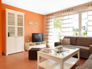 a living room with a couch and a tv at Haus Seeschwalbe in Timmendorf