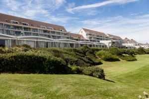 um grande edifício de apartamentos com um relvado em frente em Dolphin Beach Hotel Self Catering Apartments em Bloubergstrand