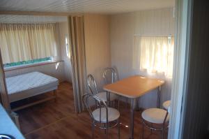 um pequeno quarto com uma mesa e cadeiras e uma cama em Ośrodek Wypoczynkowy ADA em Mielno