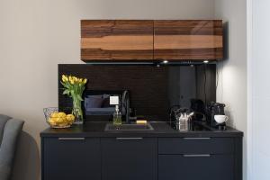 a kitchen with a black counter top and a sink at Rakowicka Top Apartaments Superior in Krakow