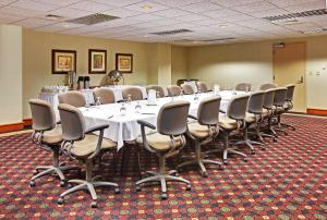 a room filled with tables, chairs, and a projector screen at Holiday Inn Memphis-University of Memphis, an IHG Hotel in Memphis