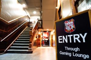 a sign for an entrance to an empty gaming lounge at The Jack Backpackers in Cairns