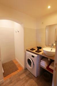 a bathroom with a washing machine and a sink at Le Loft des Artistes in Arles