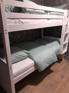 ein weißes Etagenbett mit einem Handtuch auf dem unteren Regal in der Unterkunft Luxe All season Chalet De Goudenregen in Balkbrug