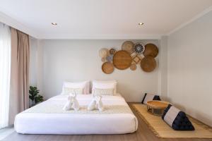a bedroom with a white bed with two white towels at VAYNA Boutique Koh Chang in Ko Chang
