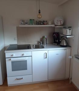 a kitchen with a white stove and a sink at Arthouse Apartment in Bad Vilbel