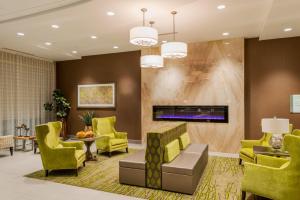 a lobby with yellow chairs and a fireplace at Holiday Inn Paducah Riverfront, an IHG Hotel in Paducah