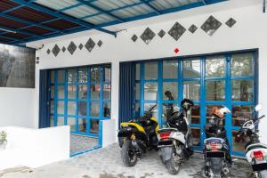 deux motos garées dans un garage avec portes bleues dans l'établissement RedDoorz near Medan Amplas, à Delitua