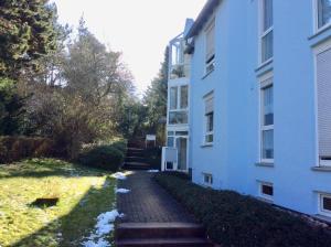 a brick path next to a white building at Ferienwohnung Rodenhof in Saarbrücken