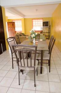 a dining table and chairs in a living room at Aanola Villas A3 Quietude Domicile in Charlotte
